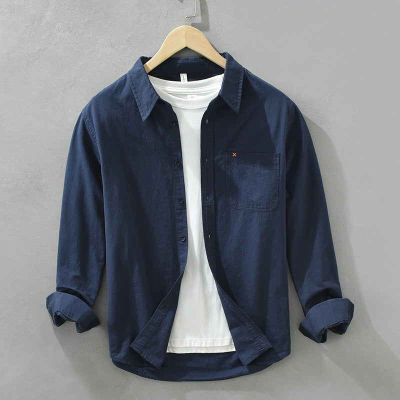 Herren Freizeithemd Dunkelblau aus 100% Baumwolle offen getragen als
Overshirt über einem weißen T-Shirt auf einem Holzbügel. Cheapseasons
Japanese Fresh Style.