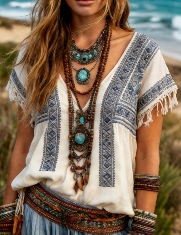 Boho-ethno shirt with tassel details by CheapSeasons, featuring colorful patterns and relaxed fit, displayed on a hanger.