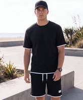 Sportliches Herren Sommer-Set aus T-Shirt und Shorts in Khaki, lässig getragen am Strand – erhältlich in großen Größen bis 4XL.