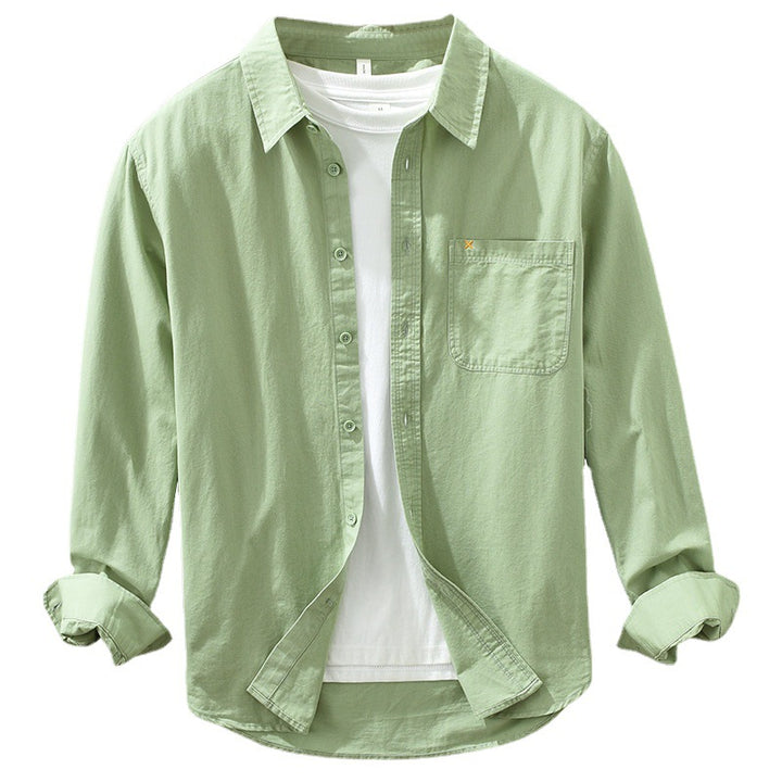 Herren Freizeithemd Salbeigrün aus 100% Baumwolle offen getragen als
Overshirt über einem weißen T-Shirt auf einem Holzbügel. Cheapseasons
Japanese Fresh Style.