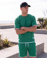 Sportliches Herren Sommer-Set aus T-Shirt und Shorts in Khaki, lässig getragen am Strand – erhältlich in großen Größen bis 4XL.