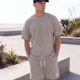 Sportliches Herren Sommer-Set aus T-Shirt und Shorts in Khaki, lässig getragen am Strand – erhältlich in großen Größen bis 4XL.