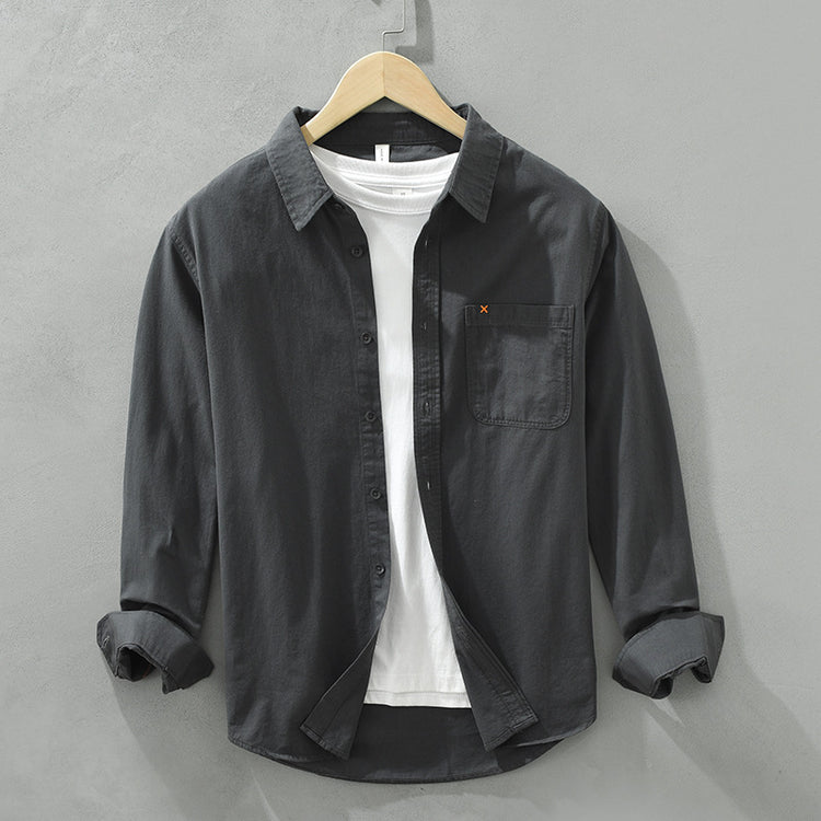Herren Freizeithemd Schwarz aus 100% Baumwolle offen getragen als
Overshirt über einem weißen T-Shirt auf einem Holzbügel. Cheapseasons
Japanese Fresh Style.