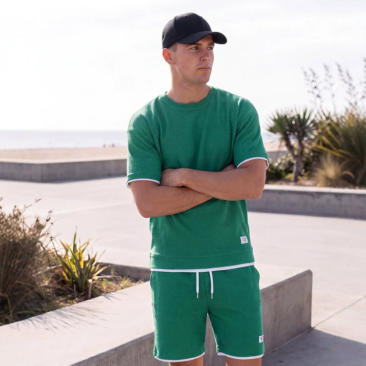 Sportliches Herren Sommer-Set aus T-Shirt und Shorts in Khaki, lässig getragen am Strand – erhältlich in großen Größen bis 4XL.