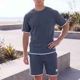 Sportliches Herren Sommer-Set aus T-Shirt und Shorts in Khaki, lässig getragen am Strand – erhältlich in großen Größen bis 4XL.
