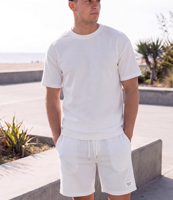 Sportliches Herren Sommer-Set aus T-Shirt und Shorts in Khaki, lässig getragen am Strand – erhältlich in großen Größen bis 4XL.
