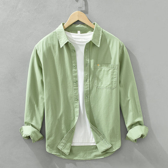 Herren Freizeithemd Salbeigrün aus 100% Baumwolle offen getragen als
Overshirt über einem weißen T-Shirt auf einem Holzbügel. Cheapseasons
Japanese Fresh Style.